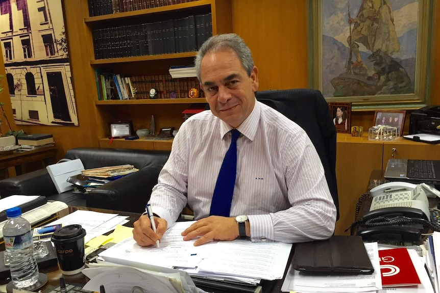 President of Athens Chamber of Commerce and Industry Constantine Michalos sits at his desk.