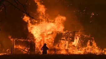 The silhouette of a firefighter fighting flames