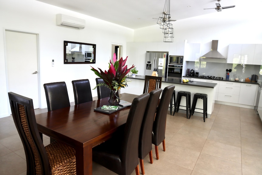 A large, open plan dining and kitchen area inside a house.
