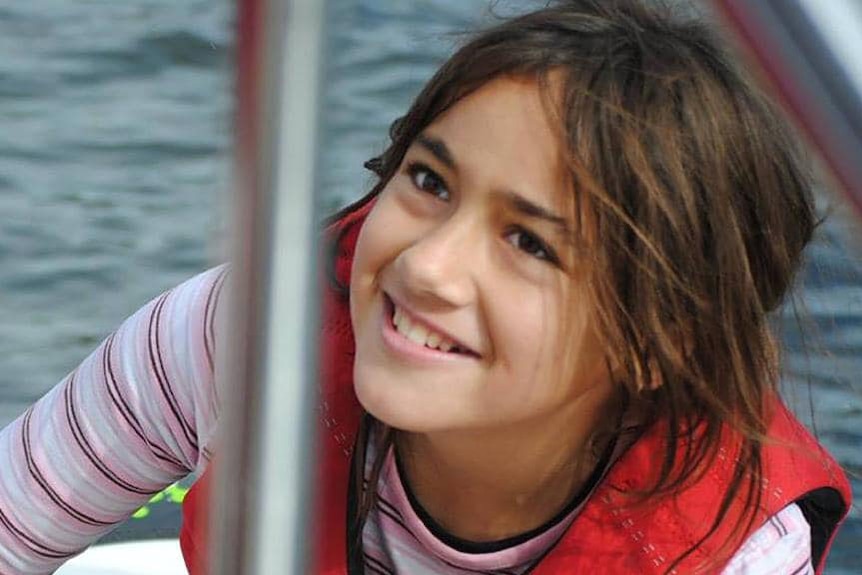 Smiling Tiahleigh Palmer on a boat wearing a life jacket, date and location unknown.