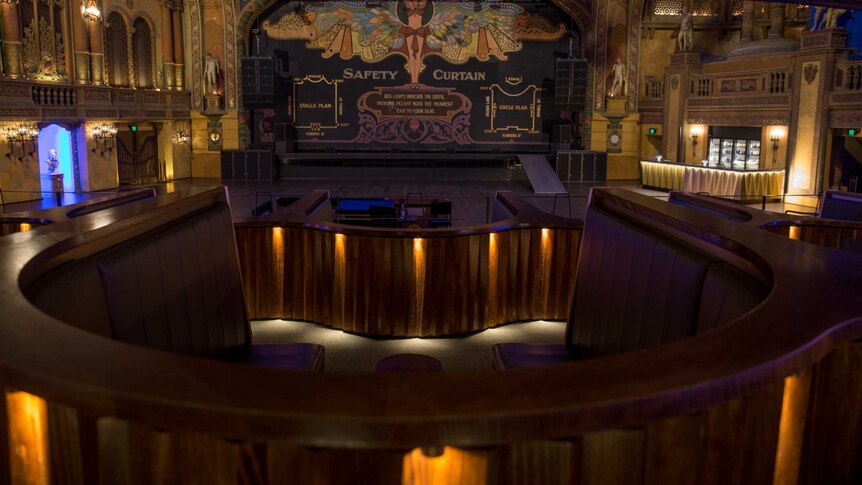 Empty booths and a bar in front of a decorated safety curtain