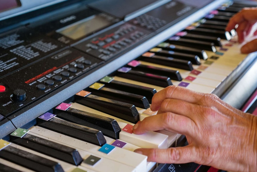 A close-up of hands playing a keyboard.