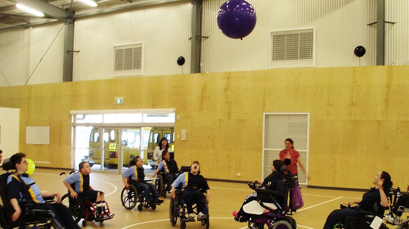 Students in their wheelchairs play soccer with a black balloon at the Adelaide super school at Taperoo