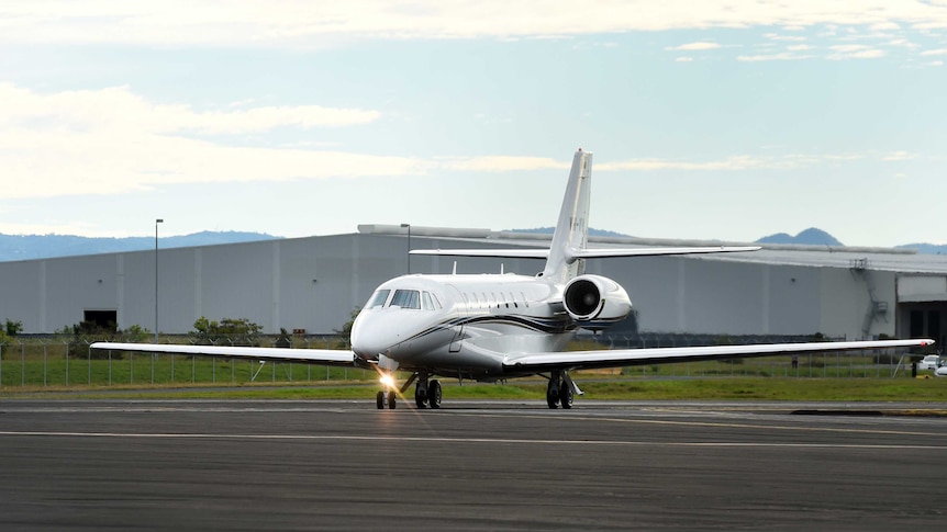 A plane carrying an injured Australian tourist arrives at Brisbane Airport.