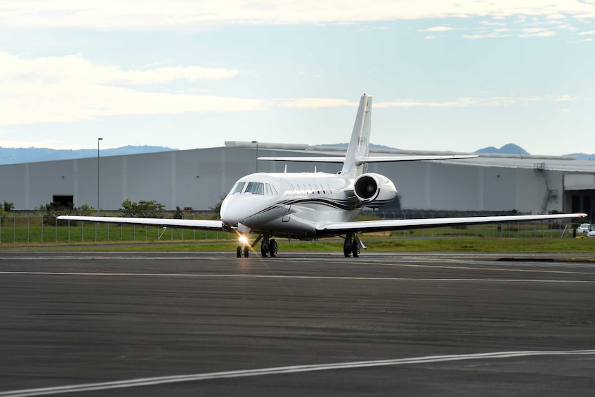 A plane carrying an injured Australian tourist arrives at Brisbane Airport.