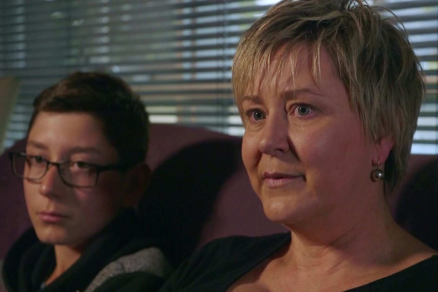 Kate Reeves and her son Will sitting on a sofa in their home.