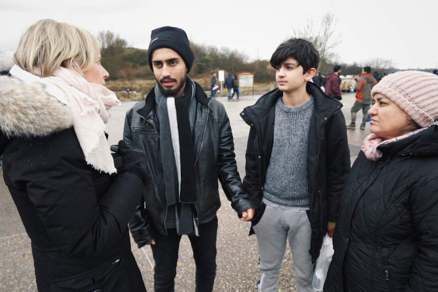 Correspondent Samantha Hawley speaks to Iraqi teenager Baran (second from left), his brother and mother.