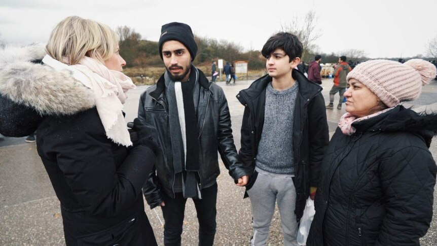 Correspondent Samantha Hawley speaks to Iraqi teenager Baran (second from left), his brother and mother.