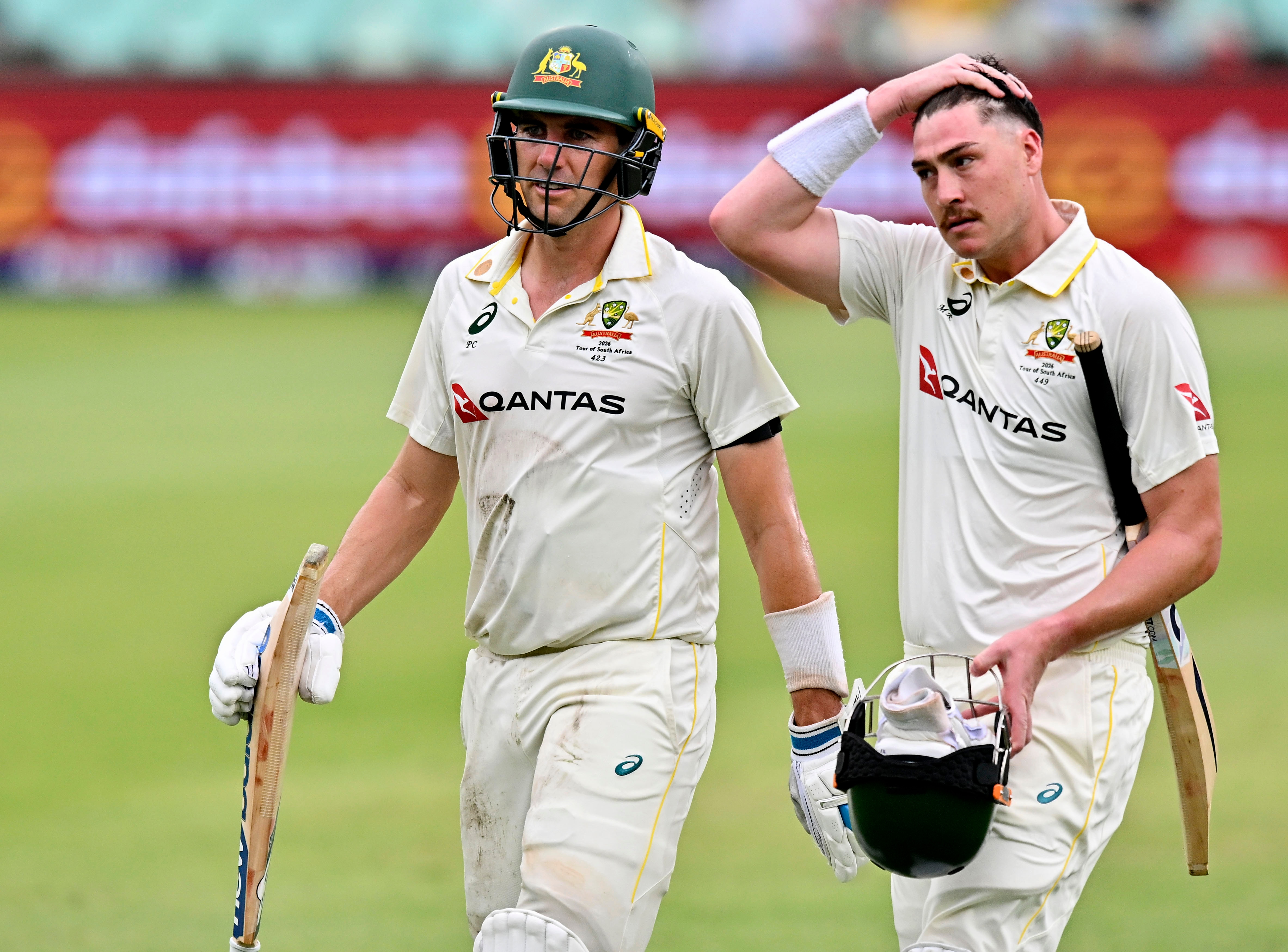Pat Cummins and Matt Renshaw walk off after a day of Test cricket in Durban. Renshaw rubs his hair.