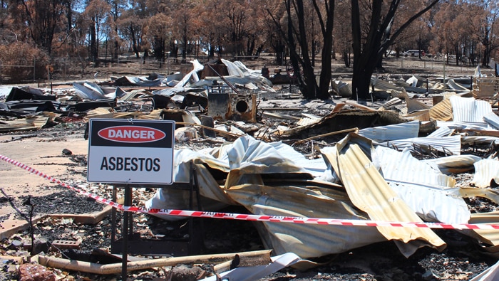 Sign warning of asbestos outside a burnt-out home in Yarloop.