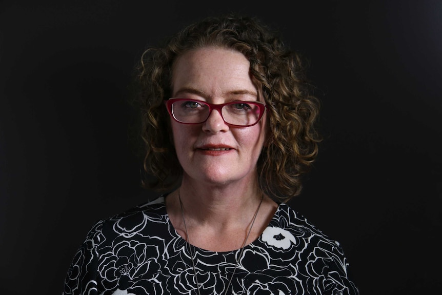 A woman with a blacked-out background behind her.