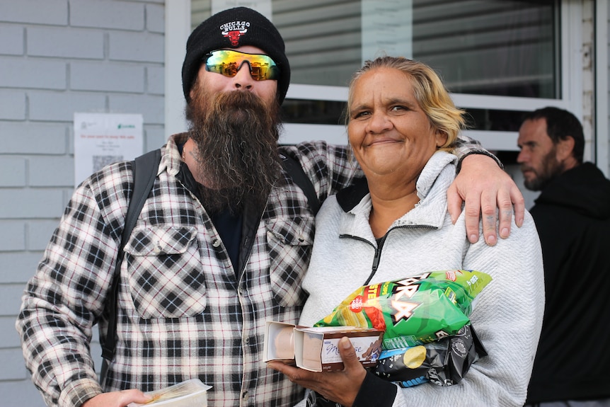 Geraldine and Matthew standing outside the soup kitchen window smiling