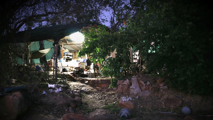 An exterior photo of Don McLeod's rustic camp at night time.
