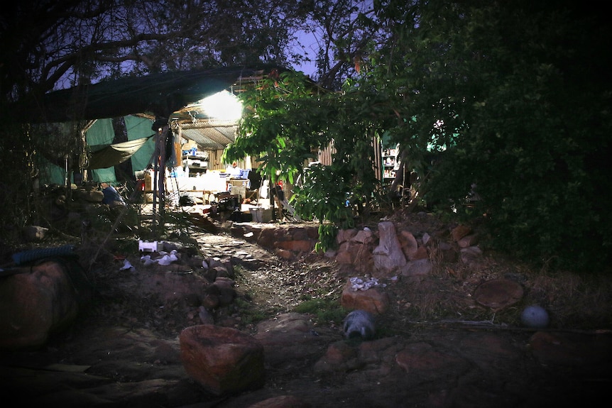 An exterior photo of Don McLeod's rustic camp at night time.