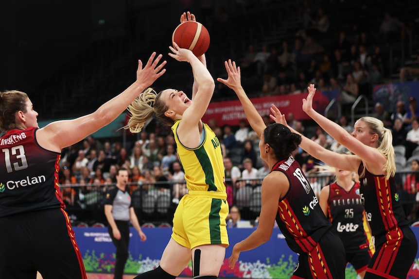 Opals captain Tess Madgen is mid-air with a look of exertion shooting the ball.