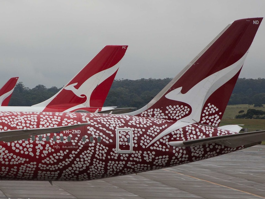 Three Qantas planes on the tarmac at Melbourne Airport on a stormy day