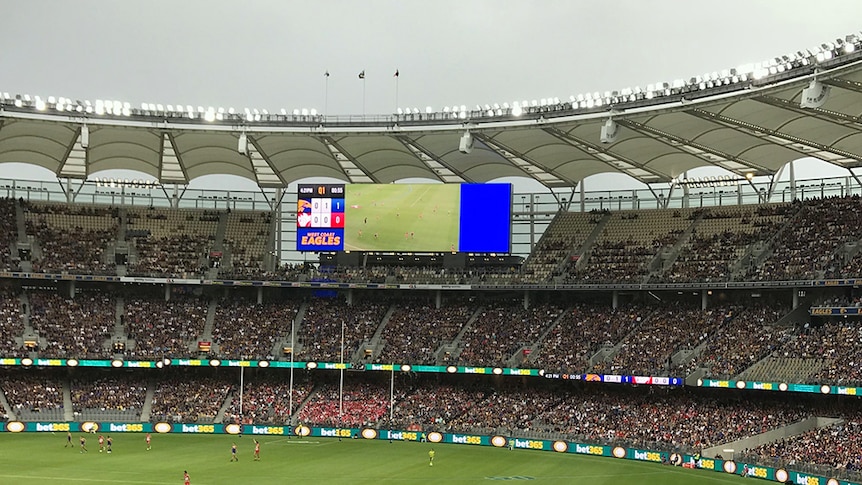 A wide shot of the stands at Perth Stadium during an AFL game with partially filled seats.