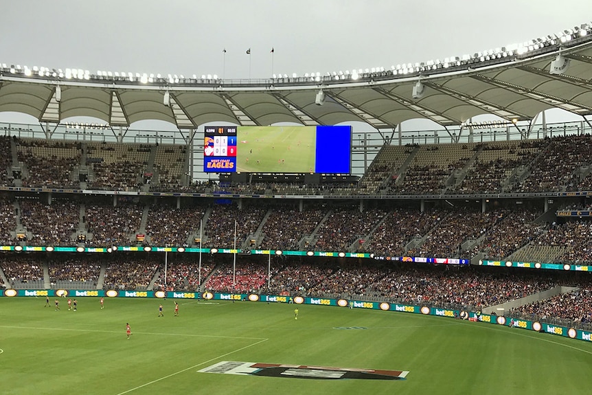 A wide shot of the stands at Perth Stadium during an AFL game with partially filled seats.