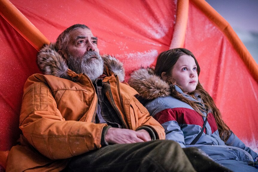 Actors George Clooney and Caoilinn Springall in arctic weather clothing in the sci-fi movie The Midnight Sky