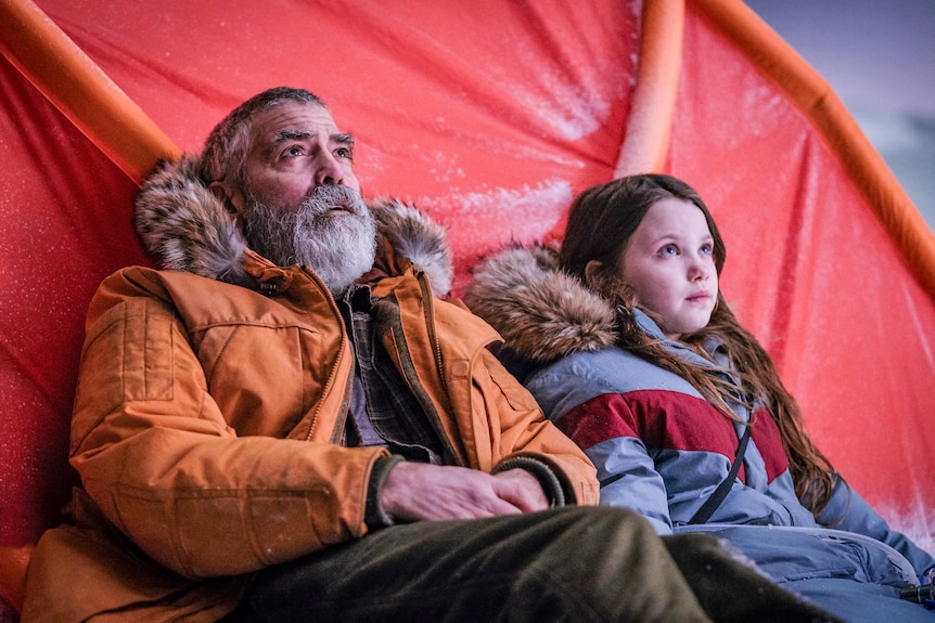 Actors George Clooney and Caoilinn Springall in arctic weather clothing in the sci-fi movie The Midnight Sky