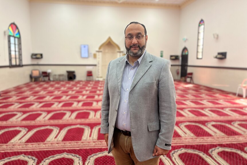 A man stands inside a mosque.