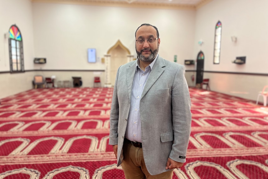 A man stands inside a mosque.