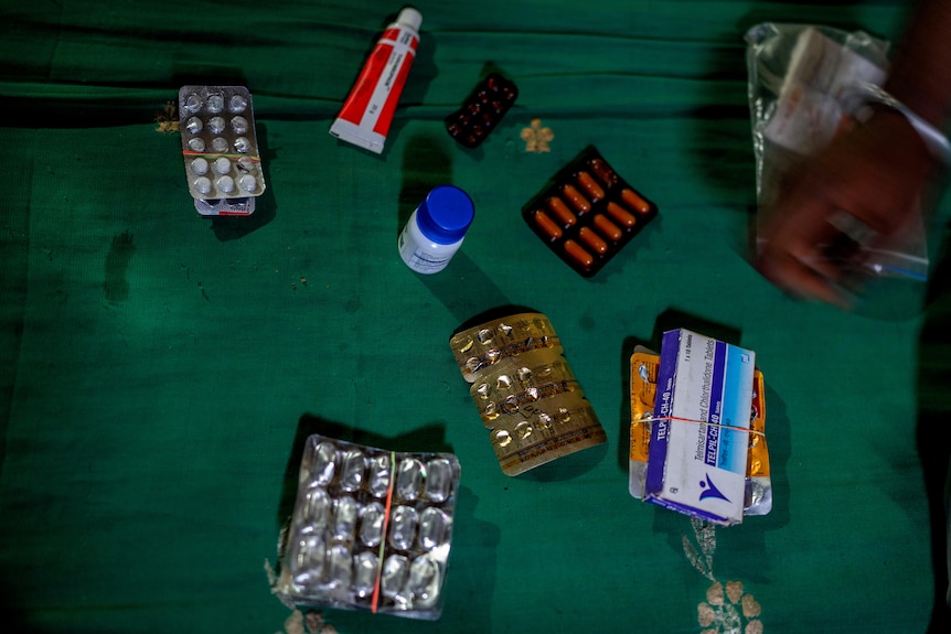 Medicines for a sickle cell patient in India are laid out on a piece of fabric