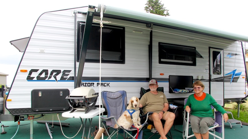 Travellers Warren and Sue Chapman sit in front of their large Recreational Vehicle