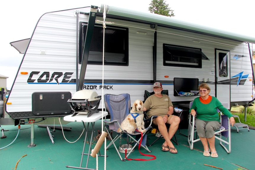Travellers Warren and Sue Chapman sit in front of their large Recreational Vehicle