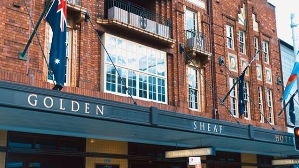 The exterior of a pub with the words Golden Sheaf Hotel on the awning.