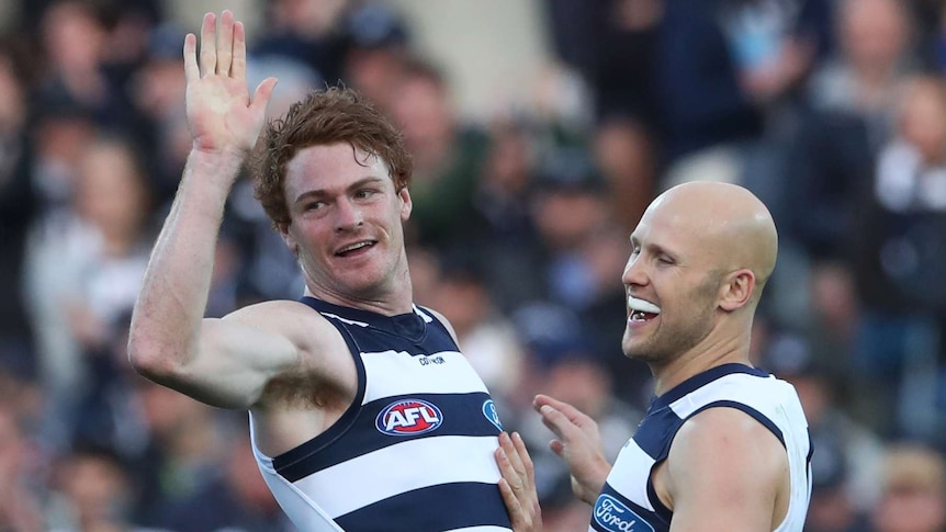 Gary Rohan raises his right hand as he is about to embrace Gary Ablett.