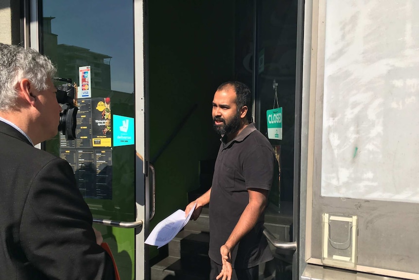 Two men speak at the door of Adithya Kerala restaurant in Nowra.