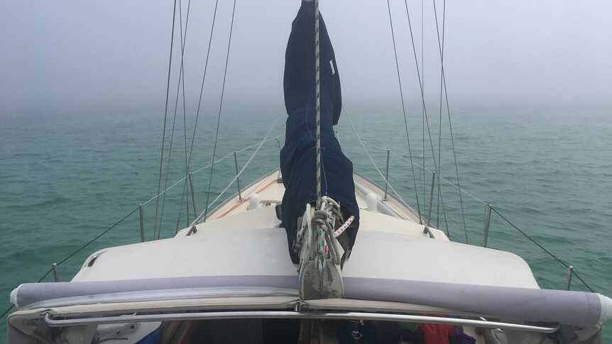 The bow of a boat on a foggy sea