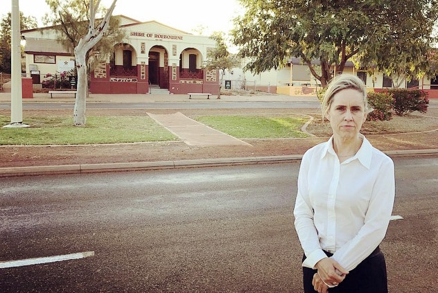Simone McGurk stands by the road in Roebourne, with the shire offices in the background.