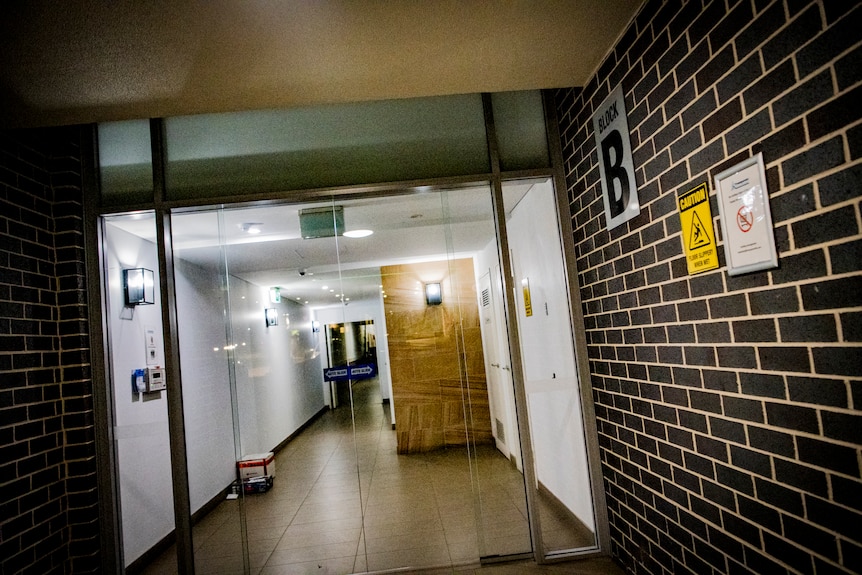 A brightly-lit front door of a modern apartment complex