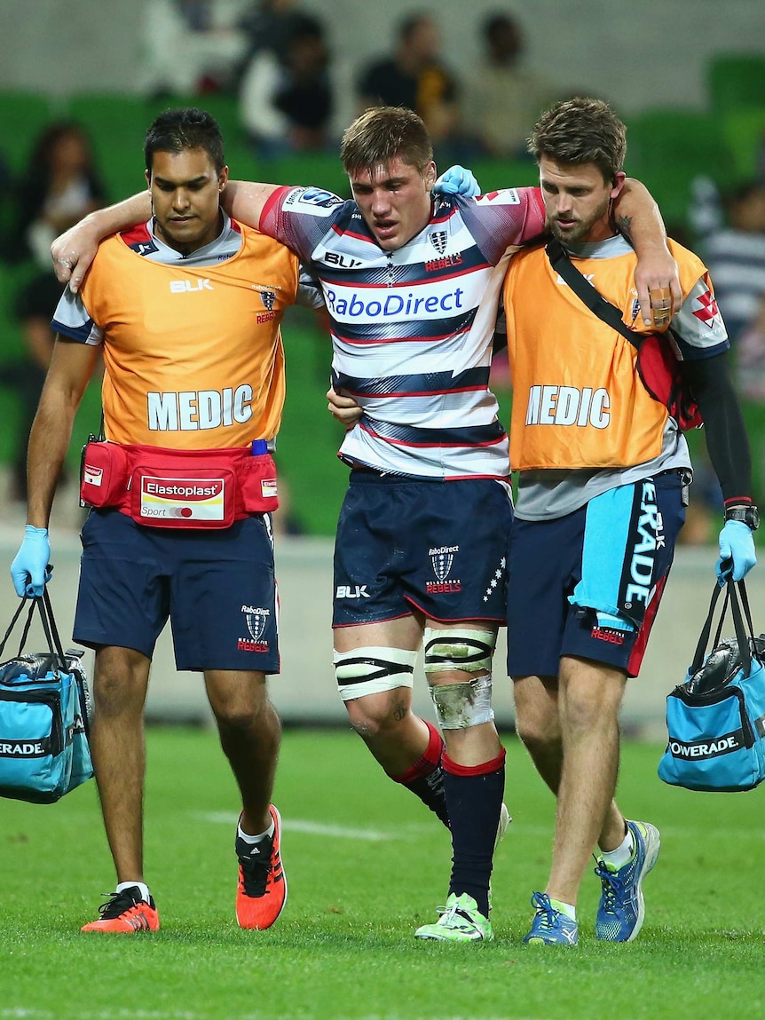Rebels Sean McMahon helped off the field after being injured against the Chiefs at AAMI Park.