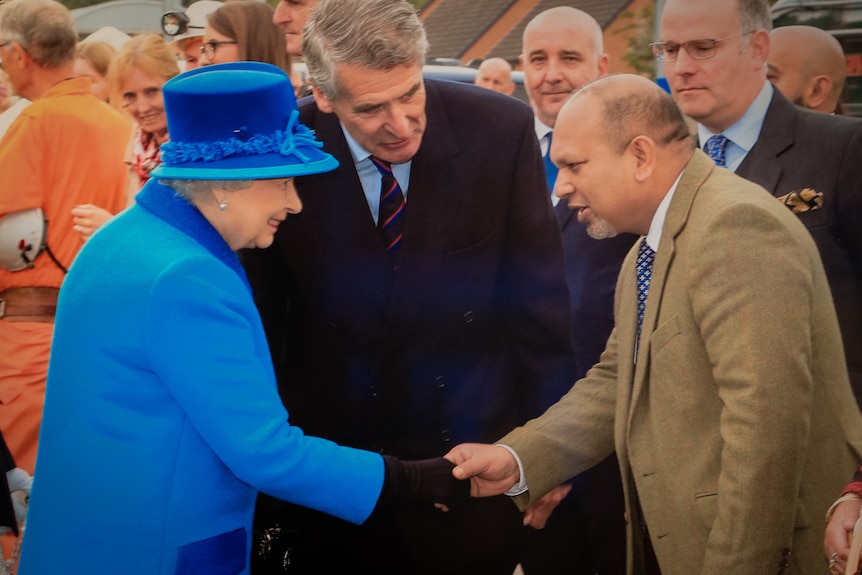 Matin Khan stringe la mano alla regina Elisabetta II.
