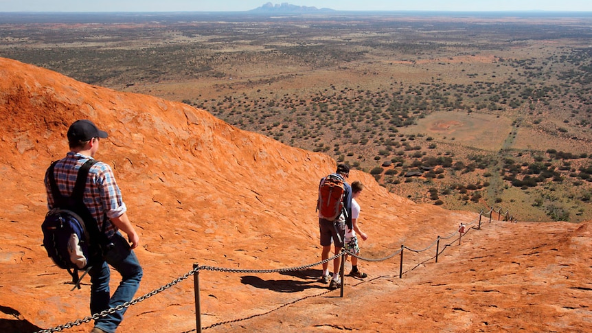 Tourists descend from their walk up Uluru