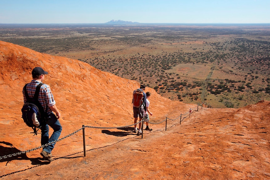 Tourists descend from their walk up Uluru