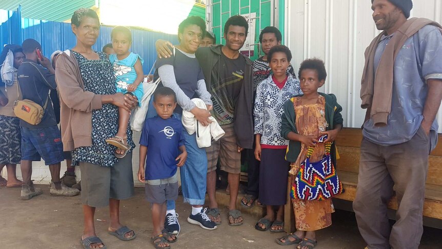 Emai surrounded by her family members in PNG.