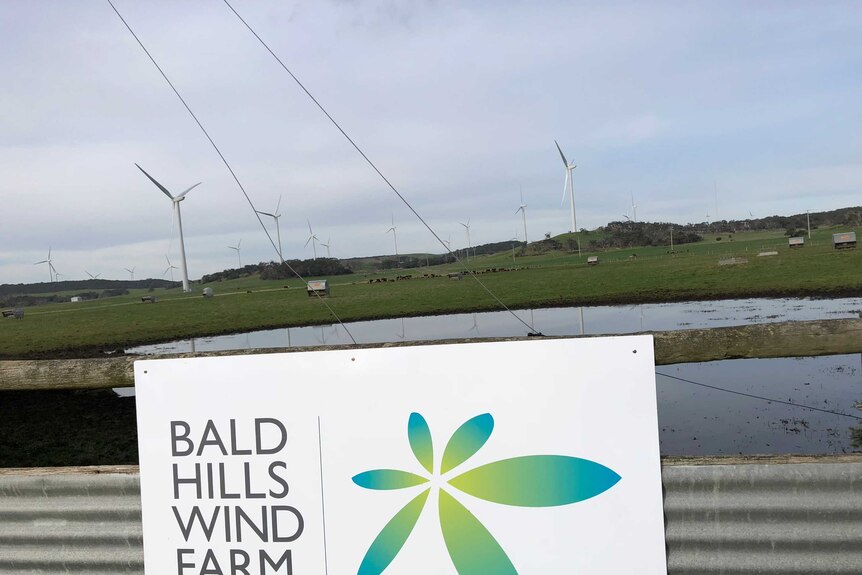 Bald Hills Wind Farm sign in front of some turbines.