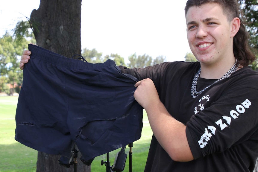 Heath Prince holding the shorts he was wearing when lashed by a wire cable strung across a Willetton road.