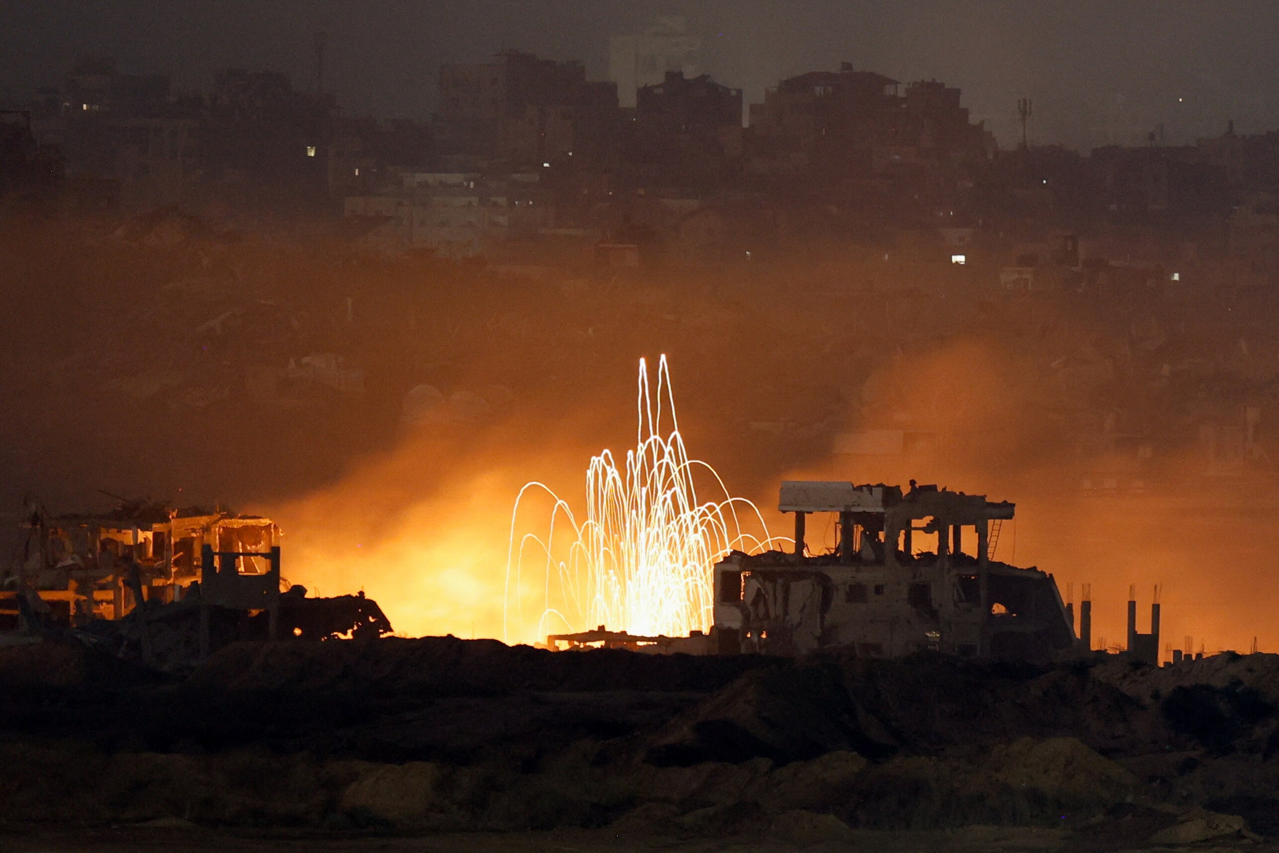Sparks can be seen against a nighttime backdrop of Gaza after an airstrike.