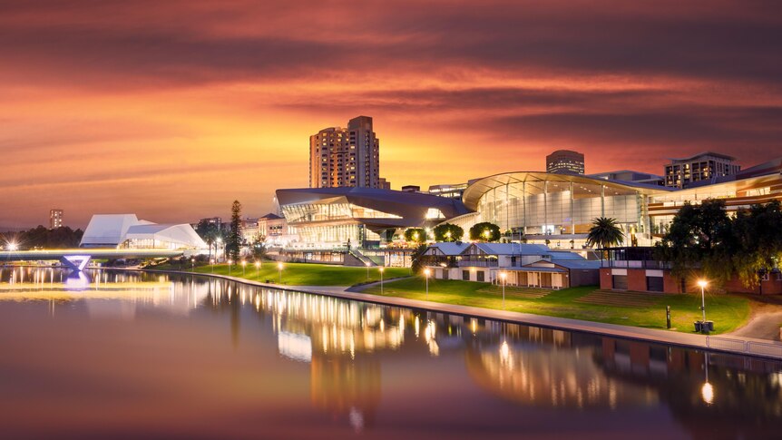 Adelaide's theatres and convention centres on the riverbank, at sunset.