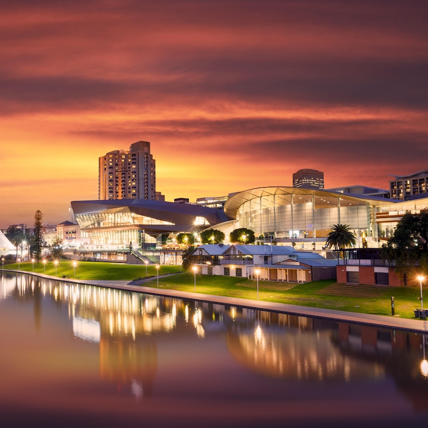 Adelaide's theatres and convention centres on the riverbank, at sunset.