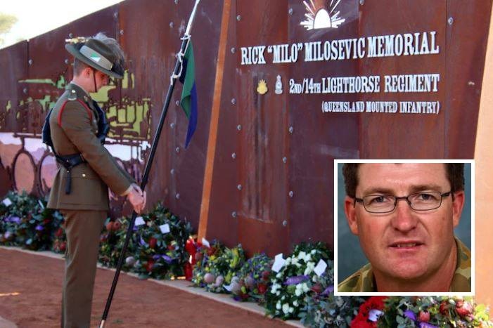 Soldier stands at the memorial for Rick Milosevic in outback Queensland.