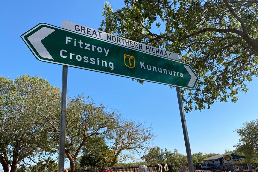 A green road sign points to Fitzroy Crossing on the left and Kununurra on the right