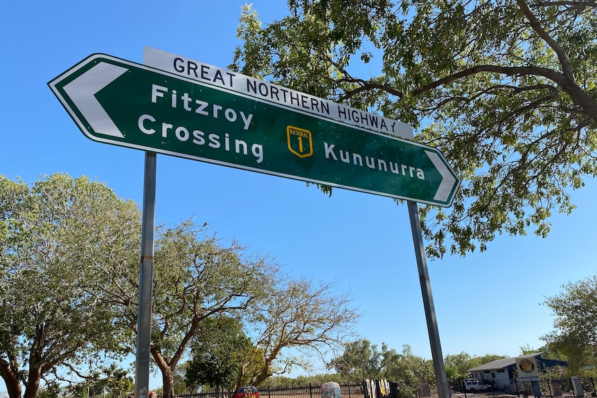 A green roadsign points to Fitzroy Crossing on the left and Kununurra on the right