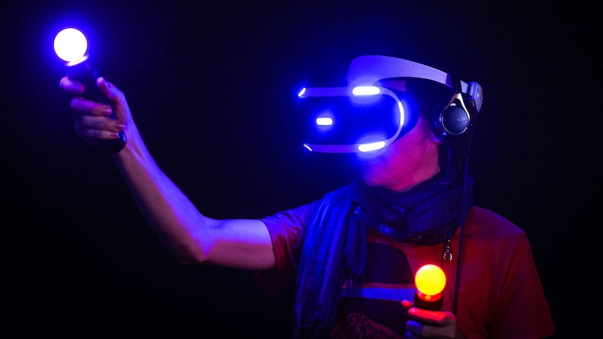 A man plays with the PlayStation VR system and Move motion controllers.