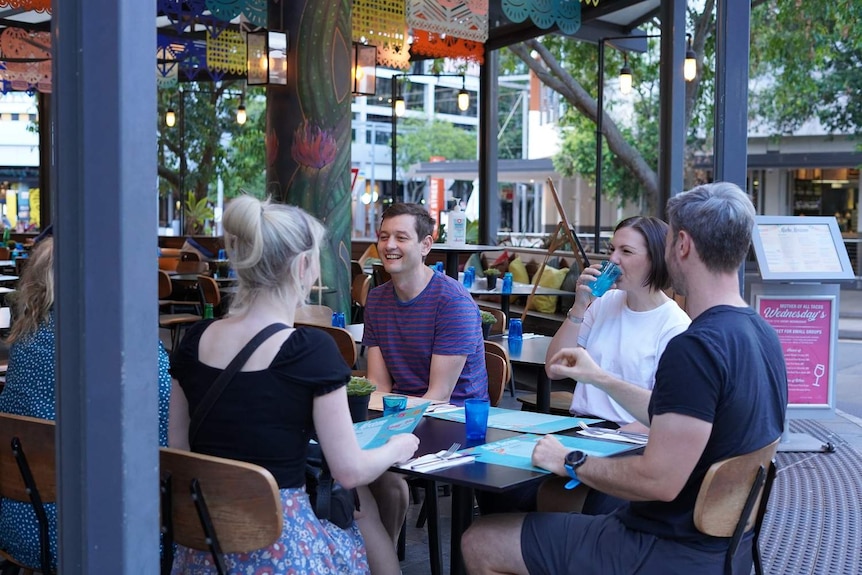 A group of people sit at a restaurant in Brisbane at South Bank.